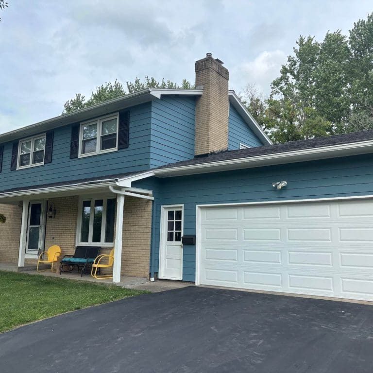 professionally painted blue home exterior with brick accents in rochester neighborhood