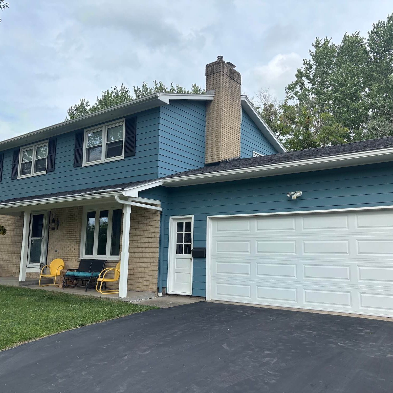 professionally painted blue home exterior with brick accents in rochester neighborhood